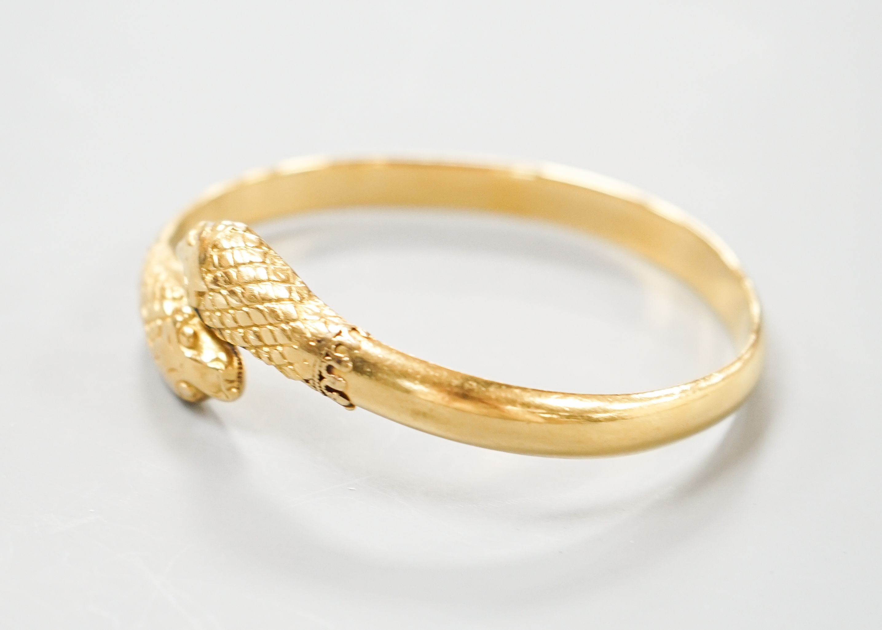 An Indian yellow metal twin headed serpent bangle